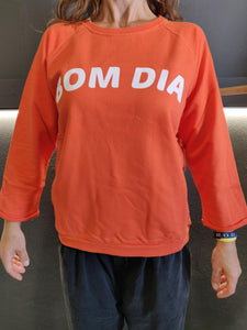 Fatum Bom Dia in Orange. Model is wearing an S and is 164cm tall and 50kgs.